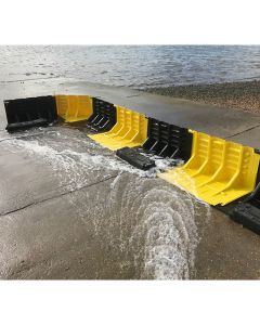 Modular flood barrier corner unit redirecting tidal water on concrete surface.